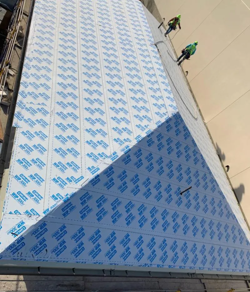 Professional roofers installing underlayment on a metal roof in Brockton